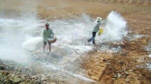 a few men spraying water on a field